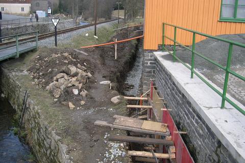 Ab dem Widerlager der Straßenbrücke wird eine zusätzliche Betonabdichtung an das Fundament der Lagerhalle angebracht.