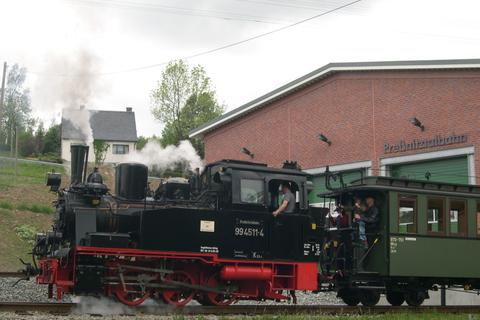 99 4511 und der Oberlicht-Personenwagen sind im Pendelverkehr zwischen Bahnhof Jöhstadt und Fahrzeughalle im Einsatz.
