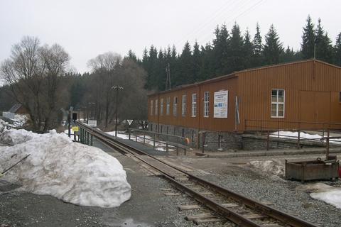Blick über den Bahnübergang an der Fahrzeughalle in Richtung der alten Lagerhalle.