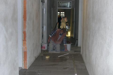 Der Fußboden des Erdgeschoßflures im Mehrzweckgebäude wird gefliest.