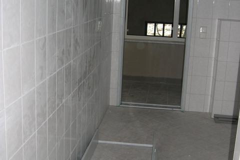Der Sanitärraum im Obergeschoß des Mehrzweckgebäudes hat seine Türzarge erhalten, auf dem Fußboden liegt die Türzarge für die Toilette.