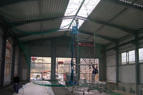 Mit der Fertigstellung der Lichtkuppeln kann das Sicherungsnetz unter dem Trapezblechdach wieder abgebaut werden.
