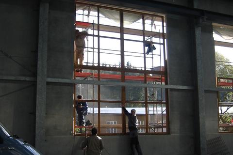 Das erste Fenster der Hallenfassade wird eingesetzt.