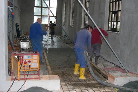 Betonierarbeiten am Unterbau des Gleises im Fahrzeugstand des Mehrzweckgebäudes.