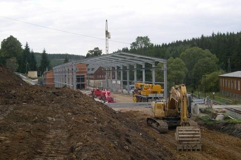 Blick vom Hang oberhalb der künftigen Gleisanlage auf die Stahlkonstruktion der Fahrzeughalle.