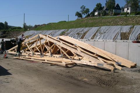 Die ersten Dachbinder werden für den Einbau auf dem Mehrzweckgebäude vorbereitet.