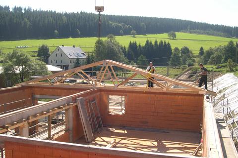 Der erste Dachbinder für das Dach des Mehrzweckgebäudes steht.