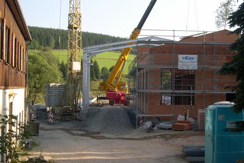 Blick auf die Baustelle von der Einfahrt an der Schlösselstraße aus mit den ersten beiden Stahlportalen der Hallenkonstruktion.