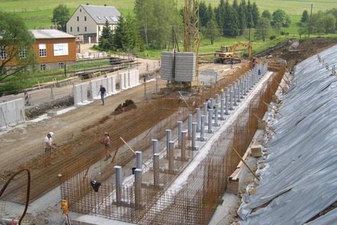 Blick vom Rest der ehemaligen Wasserkraftanlage auf die Baugrube mit den Stützen für das Gleis 3.