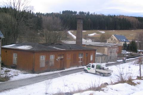 Blick auf das „Gesamtensemble“ zur Entsorgung von links nach rechts: Lagerschuppen, Heizhaus mit Schornstein und Kohlebunker mit Abstellplatz des Kohleladebaggers.