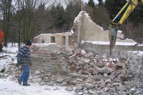 Mit dem Pickhammer am Abbruchbagger geht es an das alte Mauerwerk.