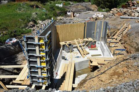 An den Innenseiten der Schalungspanele werden Holzbretter befestigt, die der Außenkontur des Widerlagerbetons dann eine sichtbare Maserung verpassen soll,