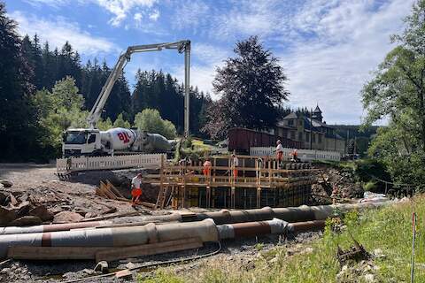 Mit dem großen Ausleger der Betonpumpe wird das Material in die Schalung für das Widerlager auf der Jöhstädter Seite eingefüllt.