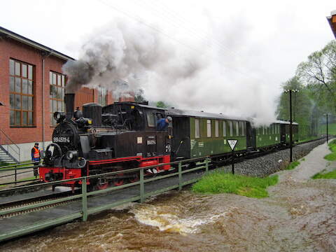 Die Dampflok 99 4511-4 passiert die Brücke am Streckenkilometer 22.2, bei der das Hochwasser bereits bis fast an den Schienenfuß heranreicht.