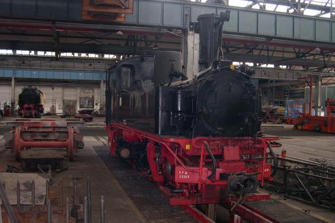 Die Lok steht in der Lokrichthalle des Dampflokwerkes Meiningen auf dem 750-mm-Schmalspurgleisstand.